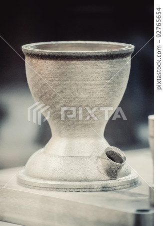 Man is holding object printed on metal 3d printer. Object printed in laser sintering machine. Modern 3D printer printing from metal powder. Progressive additive DMLS, SLM, SLS 3d printing technology Man is holding object printed on metal 3d printer. Object printed in laser sintering machine. Modern 3D printer printing from metal powder. Progressive additive DMLS, SLM, SLS 3d printing technology 92765654