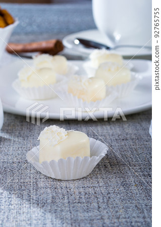 Chocolates in heart shaped white chocolate on the tablecloth 92765755