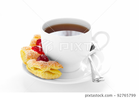 cup of tea on a saucer and cake. 92765799