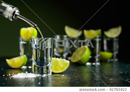Tequila shots with lime slices and sea salt. Tequila shots with lime slices and sea salt. 92765922