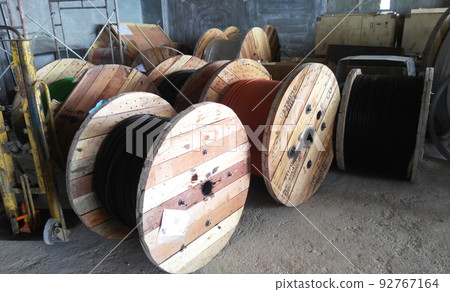 SELANGOR, MALAYSIA - JULY 7, 2022: PVC-coated electrical cables coiled in wooden drums. The use of a drum can help speed up the installation and ensure that the cable is not damaged. SELANGOR, MALAYSIA - JULY 7, 2022: PVC-coated electrical cables coiled in wooden drums. The use of a drum can help speed up the installation and ensure that the cable is not damaged. 92767164