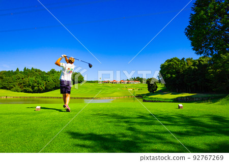 Rear view of a man hitting a driver shot over a pond on the tee ground of a golf course (Kisarazu City, Chiba Prefecture) Rear view of a man hitting a driver shot over a pond on the tee ground of a golf course (Kisarazu City, Chiba Prefecture) 92767269
