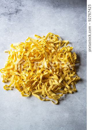 Raw uncooked pasta on a gray background. 92767425