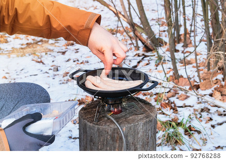 Camping food making. Tourist foods in outdoor activities. Sausages in bowler in the forest in winter. Camping food making. Tourist foods in outdoor activities. Sausages in bowler in the forest in winter. 92768288