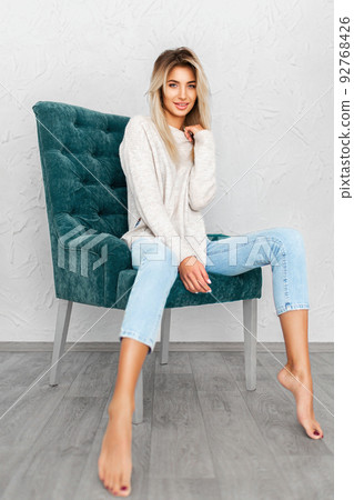 Portrait of pretty blonde woman sits on a chair. Studio shot Portrait of pretty blonde woman sits on a chair. Studio shot 92768426