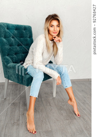 Portrait of pretty blonde woman sits on a chair. Studio shot Portrait of pretty blonde woman sits on a chair. Studio shot 92768427