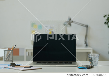 Close-up of workplace with laptop for online work at modern office Close-up of workplace with laptop for online work at modern office 92768636