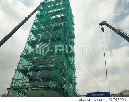 MELAKA, MALAYSIA -JULY 4, 2022: Installation of temporary scaffolding for the construction of tall concrete structures. Safety factors are prioritized to prevent accidents to workers and the public. MELAKA, MALAYSIA -JULY 4, 2022: Installation of temporary scaffolding for the construction of tall concrete structures. Safety factors are prioritized to prevent accidents to workers and the public. 92768994