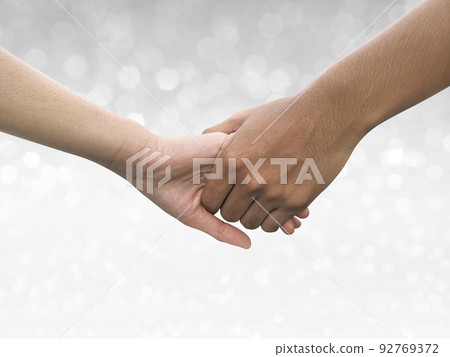 Image of a couple holding hands on shining bokeh background 92769372