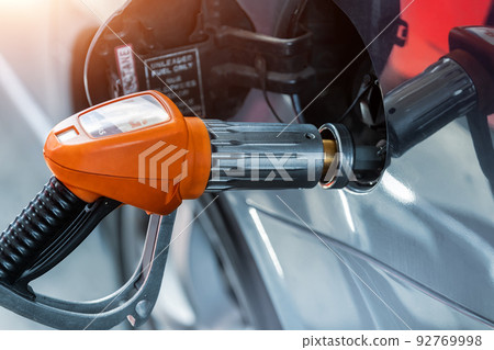 Close-up detail view of fuel autogas pump gun connected with noozle adapter to car tank to refill at car gas filling station. Refueling vehicle with liquefied lpg or lng product. Safety technology 92769998