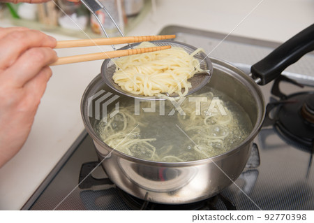 [Middle housewife boil ramen noodles with chopsticks and bamboo basket] 92770398
