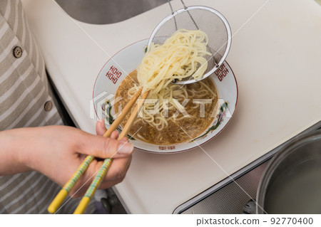 [中間主婦將煮好的拉麵放入碗中] 92770400