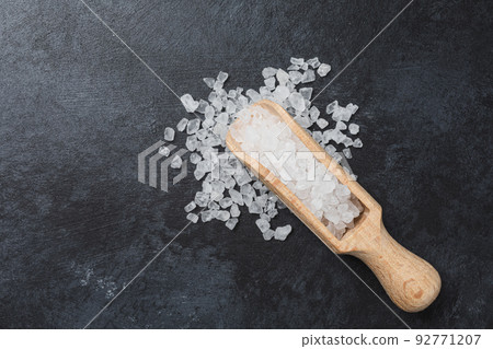 Sea salt in wooden bowl on black table. Sea salt in wooden bowl on black table. 92771207