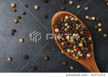 Pepper in wooden bowl on dark black stone table with copy space. Pepper in wooden bowl on dark black stone table with copy space. 92771215