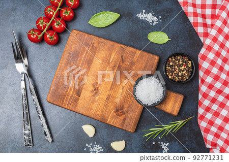 Wooden cutting board and spices, herb for food on black stone table 92771231