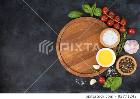 Wooden cutting board and spices, herb for food on black stone table Wooden cutting board and spices, herb for food on black stone table 92771242