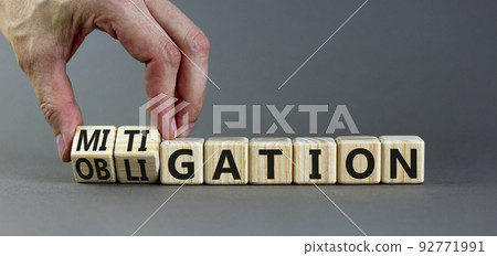 Obligation and mitigation symbol. Businessman turns wooden cubes changes the concept word obligation to mitigation. Beautiful grey background copy space. Business obligation and mitigation concept. 92771991