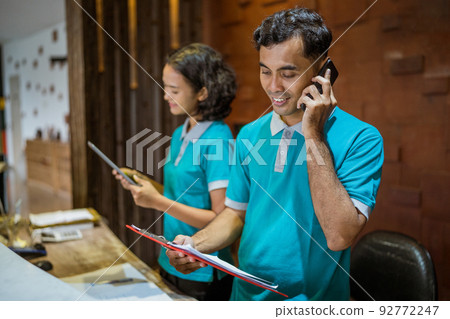 receptionist takes a phone call and takes notes receptionist takes a phone call and takes notes 92772247