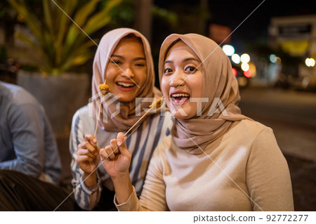 friend eating satay break fasting in traditional food stall 92772277