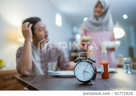 woman serving her husband some food for sahoor 92772828
