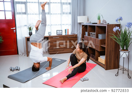 beautiful young couple doing exercise together at home beautiful young couple doing exercise together at home 92772833