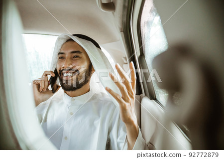 man in a turban is calling using a mobile phone while smiling man in a turban is calling using a mobile phone while smiling 92772879