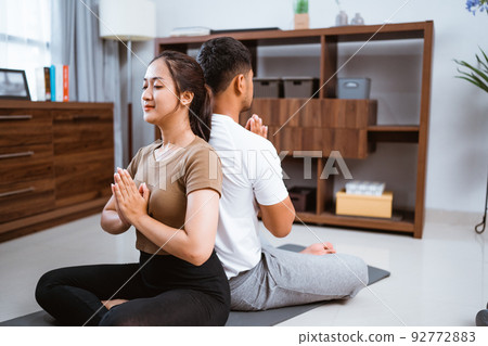woman and husband doing yoga training together at home woman and husband doing yoga training together at home 92772883