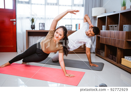 Asian fitness couple, man and woman exercising together at home Asian fitness couple, man and woman exercising together at home 92772929