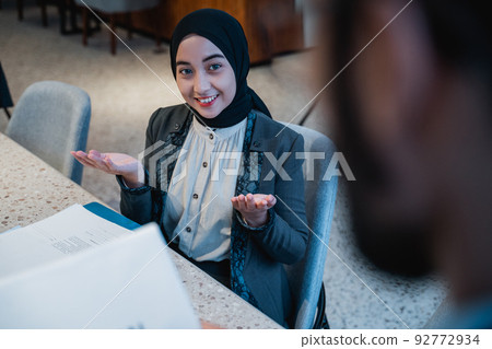 manager and employee talking about the document in the office manager and employee talking about the document in the office 92772934