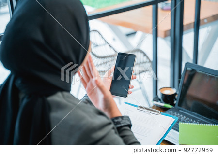 happy excited muslim woman suprised while looking at her phone happy excited muslim woman suprised while looking at her phone 92772939