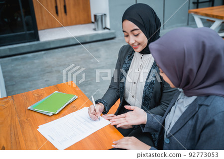 businesswoman signing an agreement letter during meeting with partner businesswoman signing an agreement letter during meeting with partner 92773053