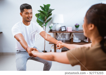 Asian fitness couple stretching at home. exercising together in livingroom Asian fitness couple stretching at home. exercising together in livingroom 92773203
