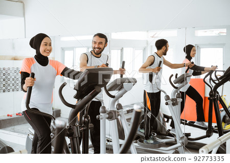 women muslim using static elliptical cycle machine at the gym women muslim using static elliptical cycle machine at the gym 92773335