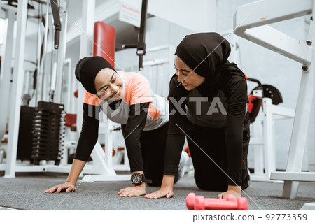 asian muslim woman doing plank push up with partner asian muslim woman doing plank push up with partner 92773359