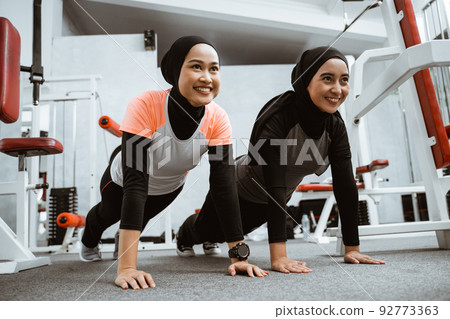 asian muslim woman doing plank push up with partner asian muslim woman doing plank push up with partner 92773363