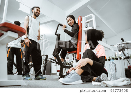 muslim sporty woman taking a break after exercising talking with friend muslim sporty woman taking a break after exercising talking with friend 92773408