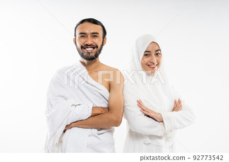 Couple wearing ihram clothes with folded hands gesture standing Couple wearing ihram clothes with folded hands gesture standing 92773542
