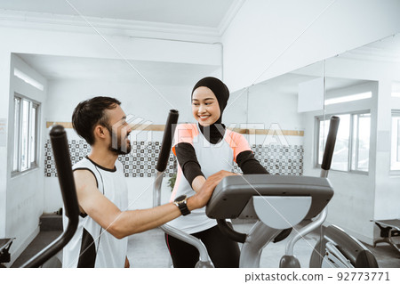 women muslim using static elliptical cycle machine at the gym women muslim using static elliptical cycle machine at the gym 92773771