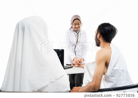 Doctor using a stethoscope examining prospective pilgrims in the room Doctor using a stethoscope examining prospective pilgrims in the room 92773856
