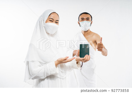 Asian couple in mask holding a passport with thumbs up Asian couple in mask holding a passport with thumbs up 92773858