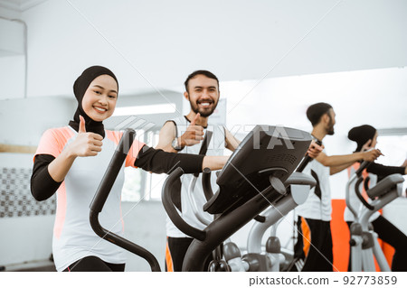 women muslim using static elliptical cycle machine at the gym thumb up women muslim using static elliptical cycle machine at the gym thumb up 92773859