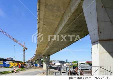 New modern road overpass concrete bridge construction site with yellow tower crane 92774010
