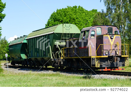 a small shunting diesel locomotive pulls two bulk wagons a small shunting diesel locomotive pulls two bulk wagons 92774022