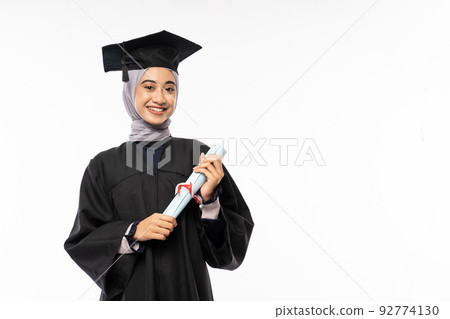 Beautiful woman wearing toga standing holding certificate roll with copyspace Beautiful woman wearing toga standing holding certificate roll with copyspace 92774130