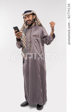 asian youth in a turban using a mobile phone excitedly over white 92774138