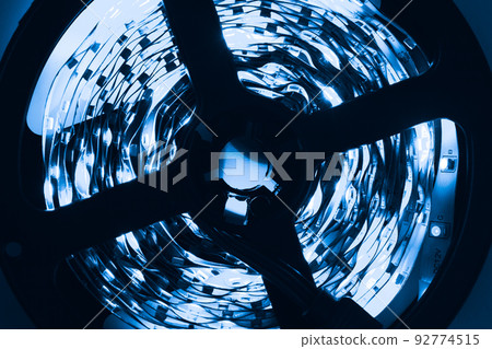 Rolled LED strip with blue lights glow in the dark, close up Rolled LED strip with blue lights glow in the dark, close up 92774515