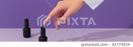 Womans hand with trendy pastel color nails over purple background. Spring summer nail design Womans hand with trendy pastel color nails over purple background. Spring summer nail design 92774834