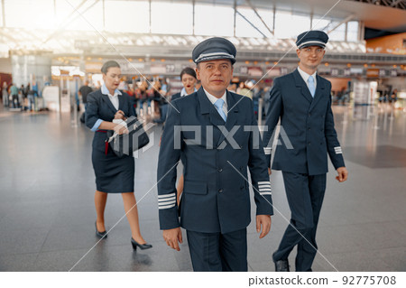 Two pilots walking along the airport terminal 92775708