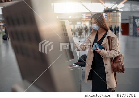 Young lady touching interactive screen to check in online Young lady touching interactive screen to check in online 92775791