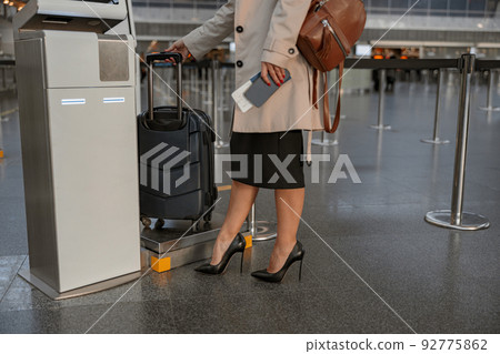 Lady standing near automatic self check-in kiosk in the airport 92775862